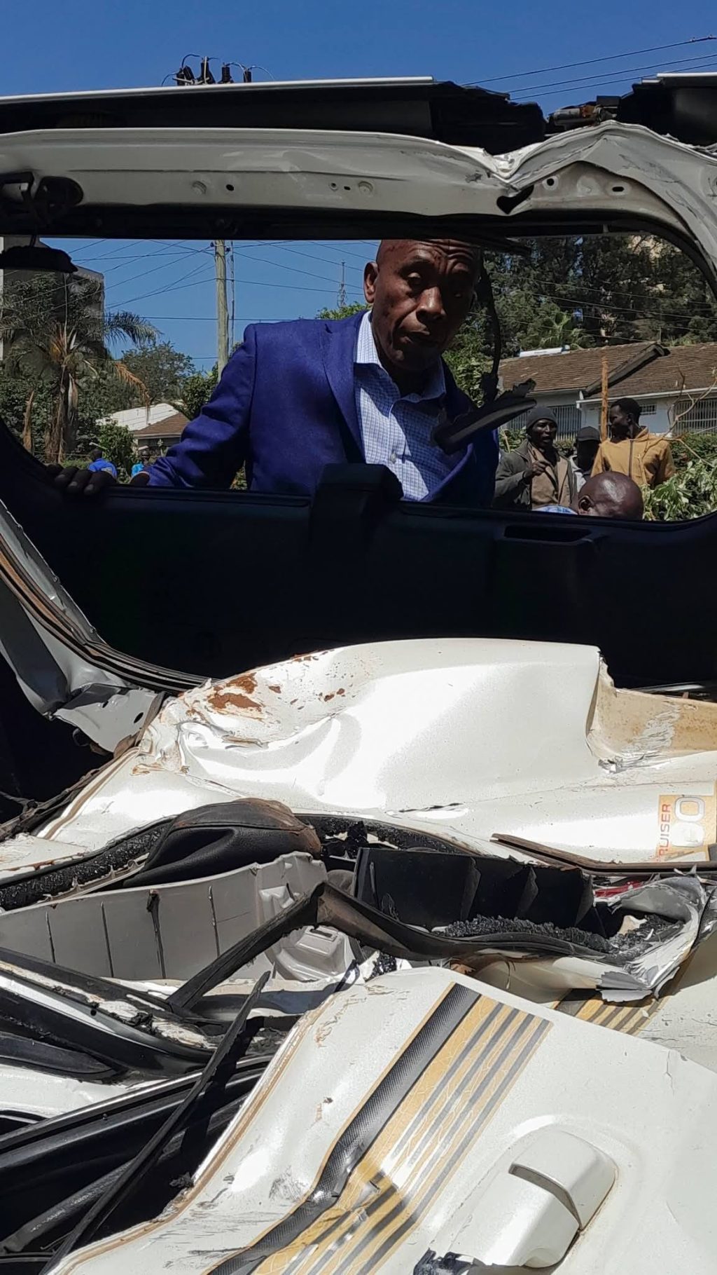 Gov Wamatangi looks inside the shell of his wife's car left behind after night destruction of his private businesses